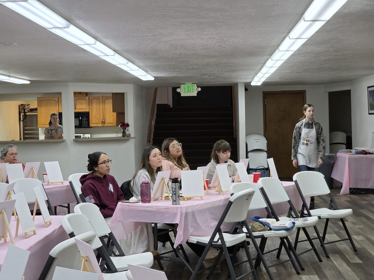 Church members gathered around tables in the fellowship hall